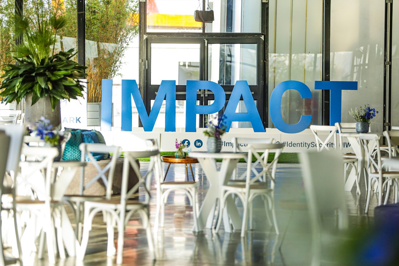 Large free-standing letters in an outdoor lounge, white cafe furniture around them.