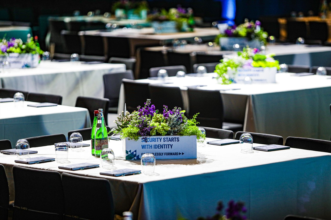 Banquet tables laid with printed cards among the place settings.