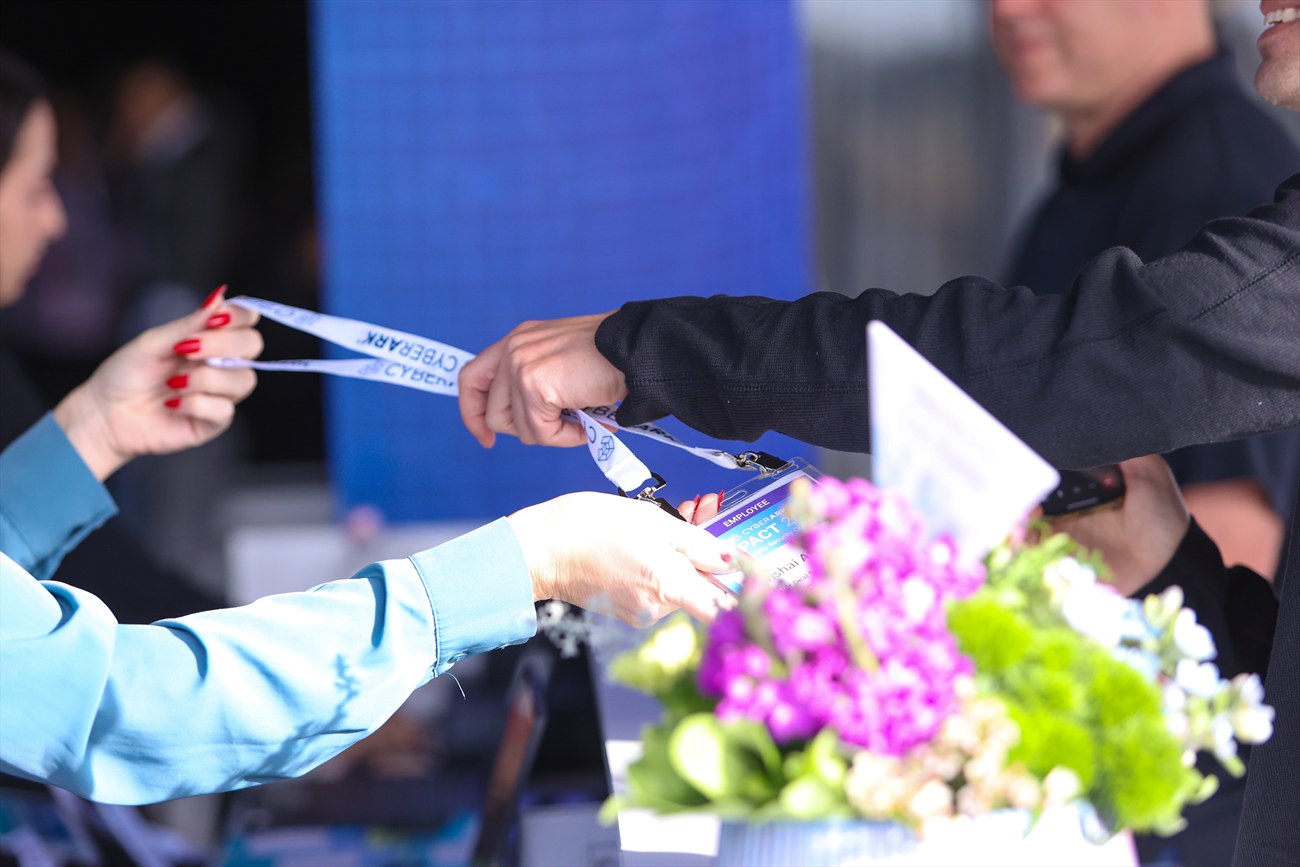 A lanyard passed from one pair of hands to another.