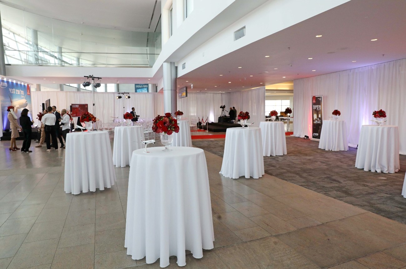 A reception in the terminal, cocktail tables under draped fabric.