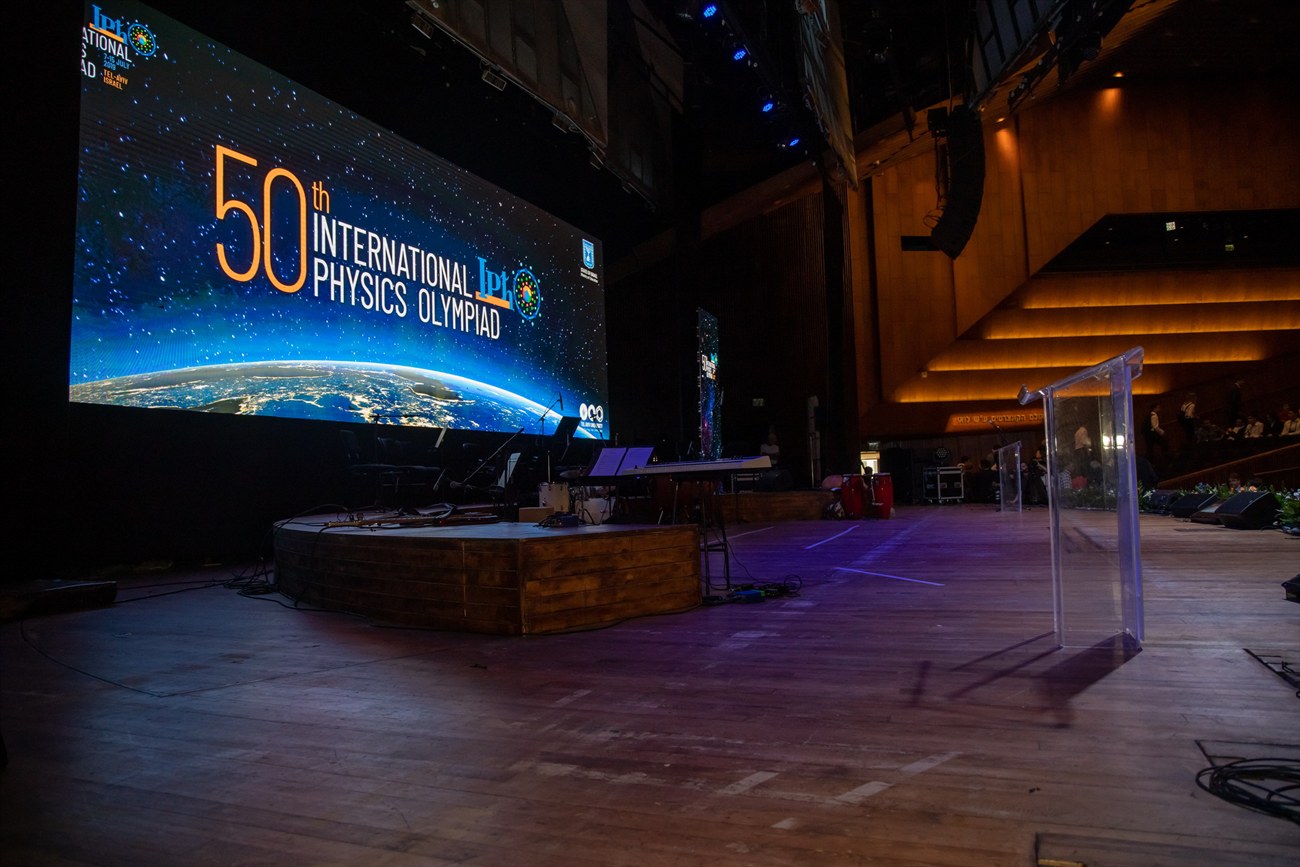The auditorium empty, a wide curved screen filling the stage.