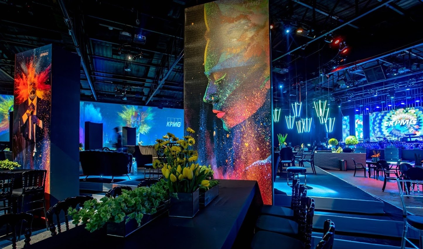 Seating and low tables under blue light, a figure crossing in the distance.