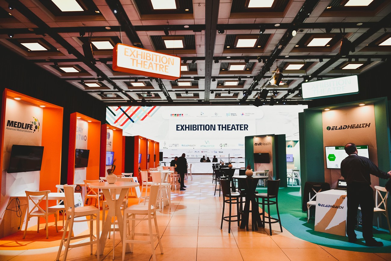 An aisle through the exhibition, signage overhead.